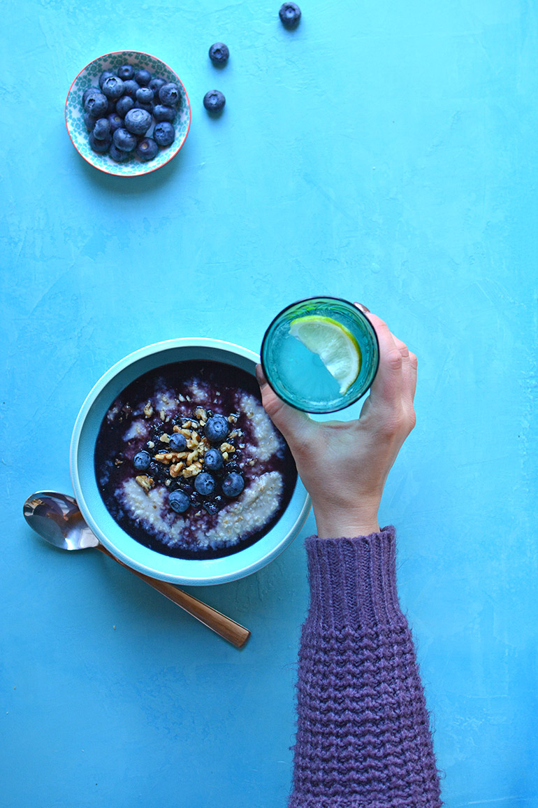 blueberry oatmeal bowl with a glass of lime water