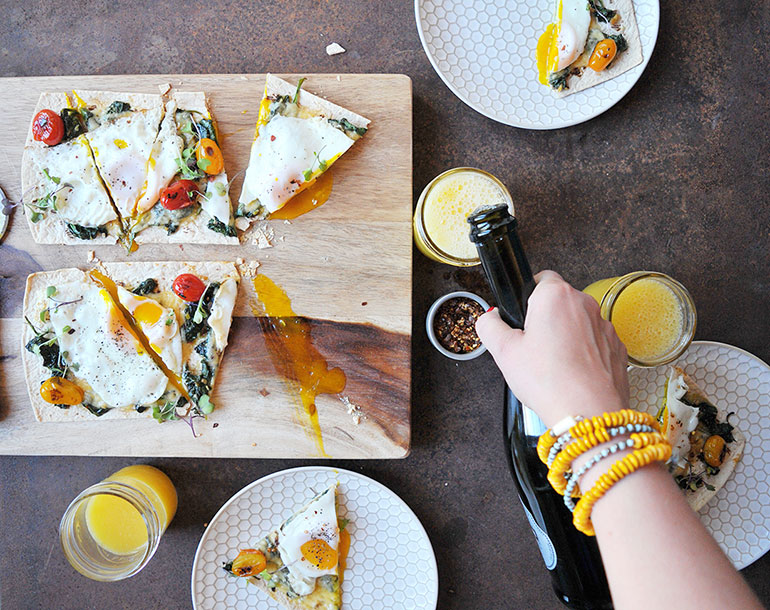 pouring mimosas with breakfast pizza
