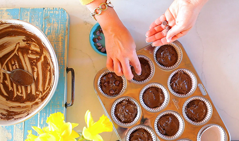 adding chocolate chips to chocolate avocado muffins