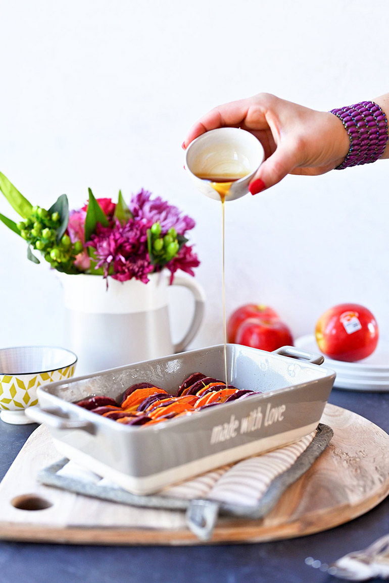 pouring syrup on baked apples and sweet potatoes