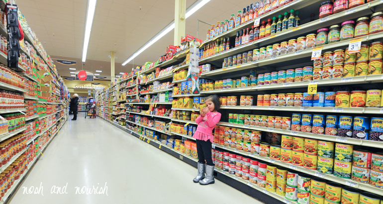 child reading nutrition labels at grocery store