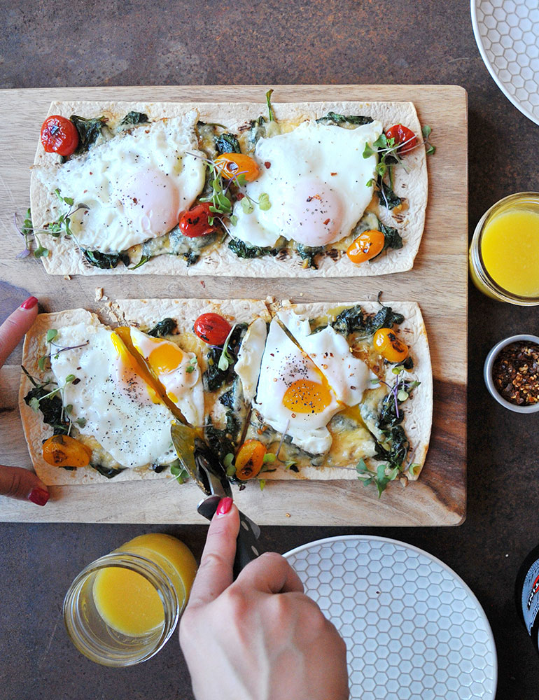 slicing breakfast pizza