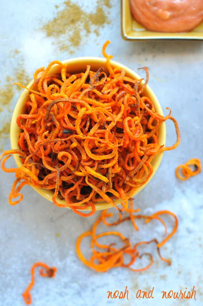 https://noshandnourish.com/sites/noshandnourish.com/files/images/curly-sweet-potato-fries-above-nosh.jpg